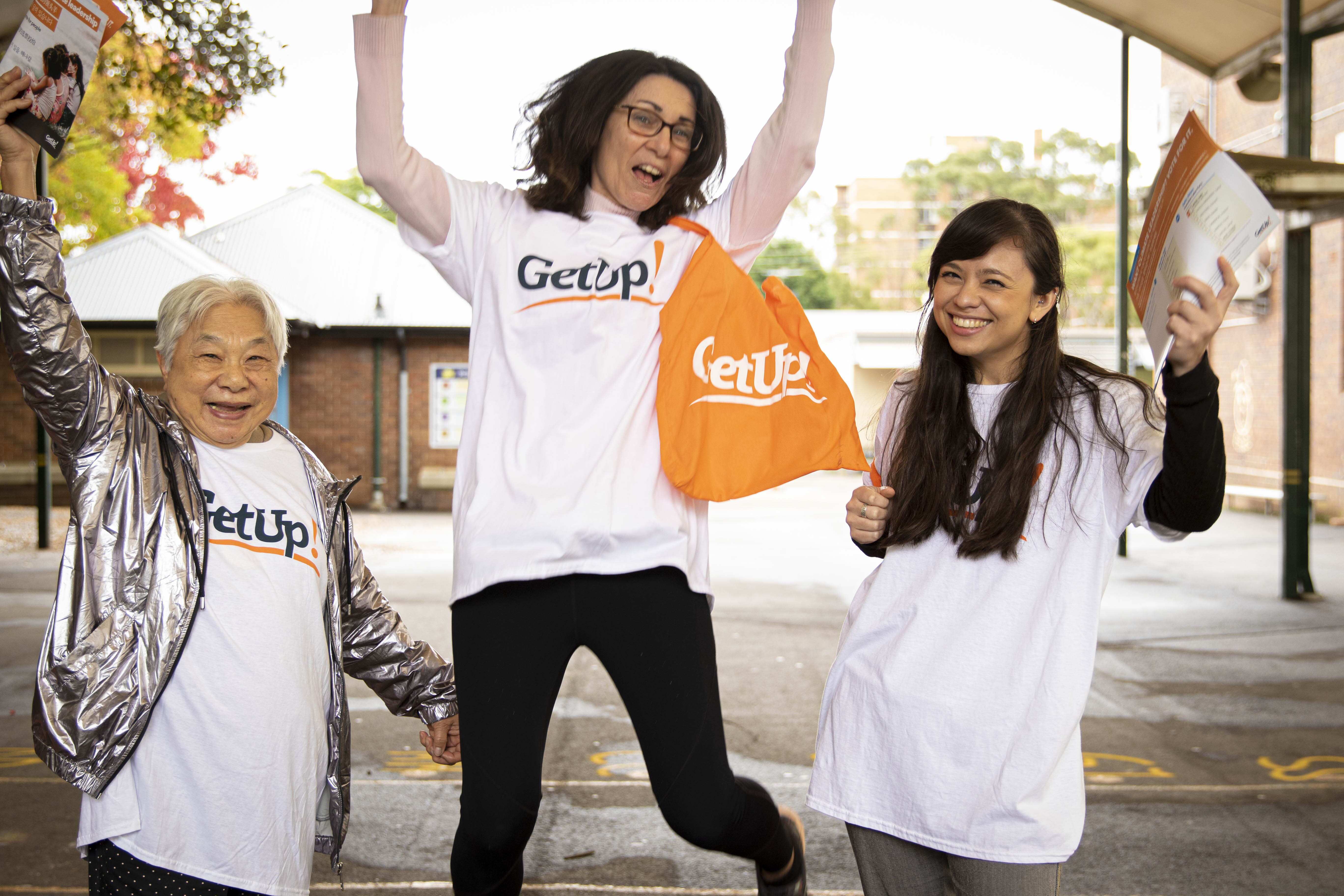GetUp community members jumping with signs
